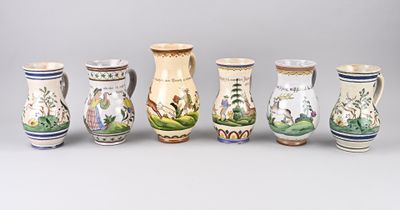 Plusieurs vases de formes variées sont alignés sur une surface grise
