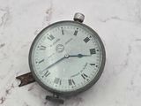 une horloge en argent ornée de chiffres romains, posée sur un socle en marbre