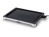 un gros plan d'une plaque de cuisson électrique noire et argentée sur fond blanc