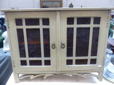 une armoire blanche avec des portes vitrées posée sur une table