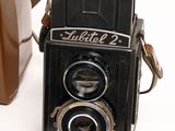 a brown camera and a brown bag on a white surface
