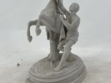 a statue of a man on a horse being held by a man