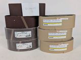 trois rouleaux de ruban adhésif marron posés les uns à côté des autres sur une table