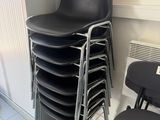 a lot of chairs that are stacked up in a room