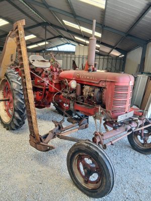 un tracteur rouge garé à l'intérieur d'un bâtiment