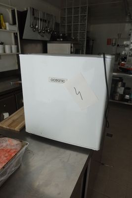 un réfrigérateur blanc posé sur un plan de travail dans une cuisine