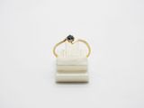 a gold ring with a black diamond sits on top of a white marble block
