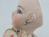 a small doll with ear piercings on it ' s head