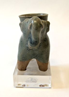 a small vase with an elephant on top of it