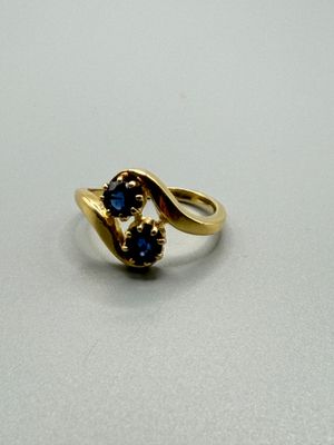 une image représentant une bague en or sertie de pierres bleues