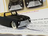 a black toy car sitting on top of a piece of paper