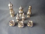 several pieces of silver metal chess pieces on a gray surface