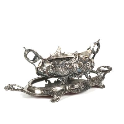 une assiette en argent décorée d'un poisson, posée sur une table