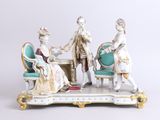 une figurine représentant trois personnes assises à une table