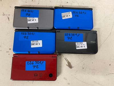 Trois Nintendo 3DS sont posées les unes à côté des autres sur une table
