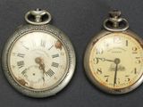 two clocks that are sitting side by side on a table