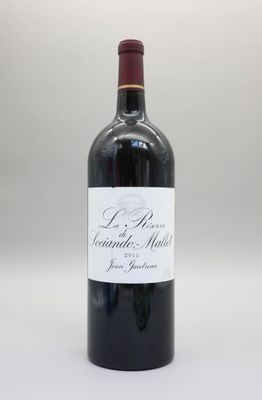 une bouteille de vin rouge posée sur une table blanche