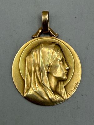 l'image d'une médaille d'or sur laquelle figure le visage d'une femme
