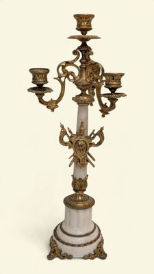 a white and gold candelier with three candles on top of it