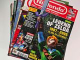 a stack of nintendo magazine covers on a table