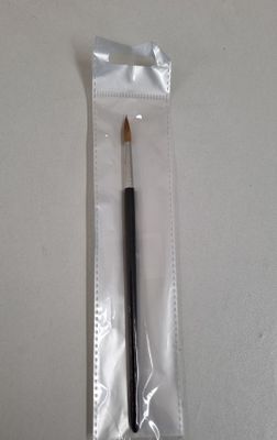 une petite brosse dans un sac en plastique posé sur une table