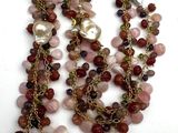 necklace with multi colored beads and pearls on a white surface