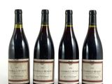 trois bouteilles de vin rouge sont alignées sur une surface blanche
