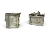 two small figurines of a man and a woman sitting on a couch