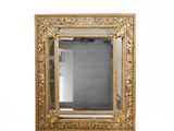 un miroir encadré d'or sur un mur blanc avec un fond blanc