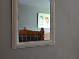 a mirror on the wall above a bed in a room