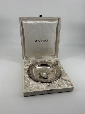 an open box with a silver object inside of it on a white surface