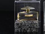a glass perfume bottle with a bird on top of it