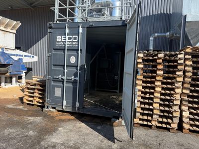 un conteneur de fret posé au milieu d'un tas de bois