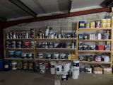 de nombreux pots de peinture et bidons sur les étagères du garage