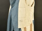 an old blue jacket with a tan patch on the front and a tan patch on the back of the jacket
