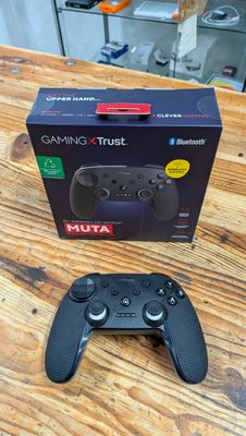 un gros plan sur une boîte posée sur une table en bois, avec une manette de jeu à côté