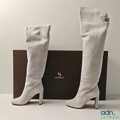 the boots are white and have gold buttons on the heel