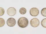six different types of coins are arranged in a row on a white surface