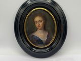 portrait d'une femme en robe bleue dans un cadre ovale noir