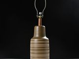 une image représentant une lampe posée sur une table, sur fond noir
