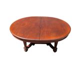 an oval dining table with two leaves on the top and two leaves on the bottom