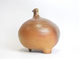 a small brown vase sitting on a white surface
