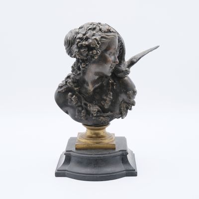 un buste antique en bronze représentant une femme tenant un couteau, posé sur un socle