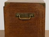 a wooden box with a metal handle on a table