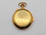an antique gold pocket watch on a white surface