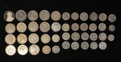 a lot of silver coins on a black surface