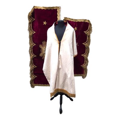 a white robe with gold trim on a mannequin stand