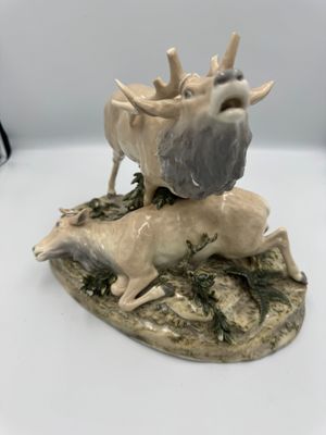 une statue représentant un cerf et une chèvre sur un rocher