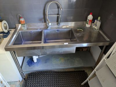 a stainless steel sink in the corner of a kitchen