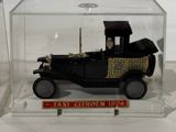 a small model of an old car in a glass case